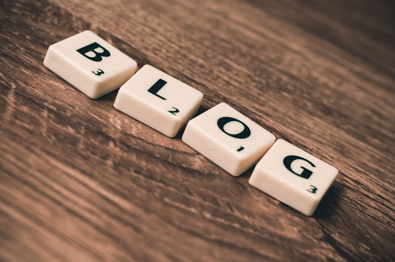 Sobre Nosotros Scrabble tiles spelling 'BLOG' on a wooden background, symbolizing creativity and writing.